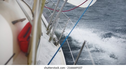 Yacht Sailing During The Storm. Close-up View From The Deck To The Bow, Mast, Sails. Dramatic Sky, Dark Clouds, Waves, Water Splashes. North Sea, Norway. Epic Seascape. Rough Weather