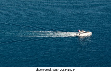 Yachting At The Sea On Summer Day. Fast Boat On The Water. Aerial Shot Of Yacht At The Seascape. Mediterranean Tourism. Sailing Ship With Water Trail