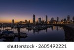 Yachts and boats at the Sharq Marina with city skyline night to day transition timelapse in Kuwait. Reflection in the water. Kuwait City, Middle East.