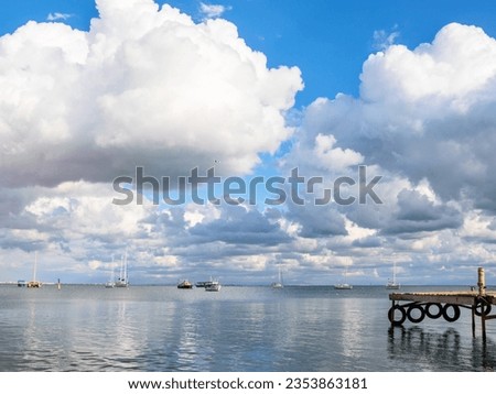 Yachts on the raid in the Evpatoria Bay in the Crimea against the backdrop of beautiful clouds. September 24, 2022
