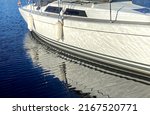 Yahts  boat  on front  in harbor reflection on sea water, marina and yahts in sunny day background 