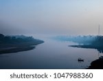  Yamuna River in the sunset with fog and a boat