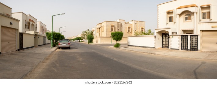 YANBU, SAUDI ARABIA - 29 OCTOBER, 2018: Cars parked on a wide empty street in a residential area of Yanbu with large private villas.