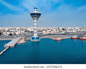 Yanbu, Saudi Arabia.  Aerial view of the iconic control tower and harbor with red tugboats docked along the pier. - Powered by Shutterstock