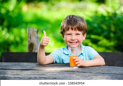 Yang little and cute boy pictured with glass of juice. - Powered by Shutterstock