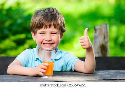 Yang little and cute boy pictured with glass of juice. - Powered by Shutterstock