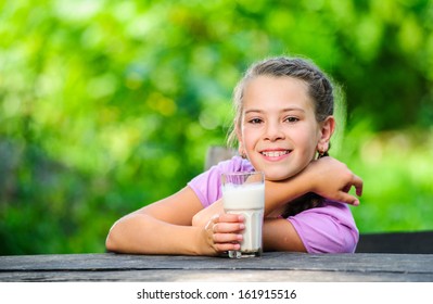 Yang pretty European girl posing with glass of milk.