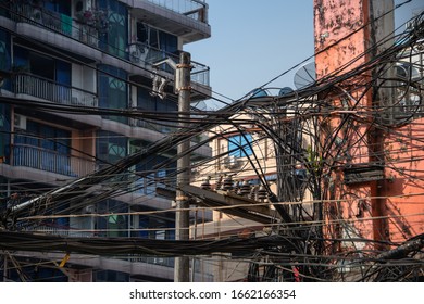 Yangon, Myanmar City Street View With A Mass Of Overhead Electrical Wires Connecting City Dwellers To The Grid.