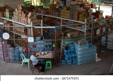 Yangon, Myanmar - December 31, 2019: A Burmese Man Guarding A Local Food And Drink Storage Enclosure Under A Bridge In Yangon