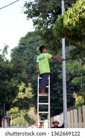 Yangon, Myanmar, Feb 22, 2019 : Myanmese Worker On The High Stairs To Cut The Branches That Are High In Yangon.