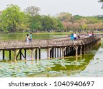 YANGON, MYANMAR - JANUARY 2, 2018: People on the wooden bridge on the Kandawgyi Lake.