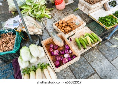 YANGSHUO, CHINA - MARCH 30, 2017: fresh local vegetables on street outdoor market in Yangshuo city in spring. Town is resort destination for domestic and foreign tourists because of scenic karst peaks