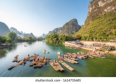 Yangshuo, Guilin, Guangxi province, China - Nov 9, 2019 : Tourist bamboo rafts arriving at the end of the tour on the river with karst limestone hills and blue sky in the background.