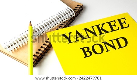 YANKEE BOND text written on yellow paper with notebook