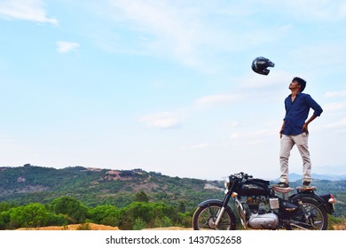 Yarcaud, India - May 12, 2019 : Rider facing helmet in air on the Royal Enfield motorcycle