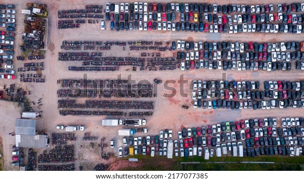 Yard\
of abandoned cars and seized for irregularity by the police. With\
many cars and many motorcycles parked. Aerial\
view