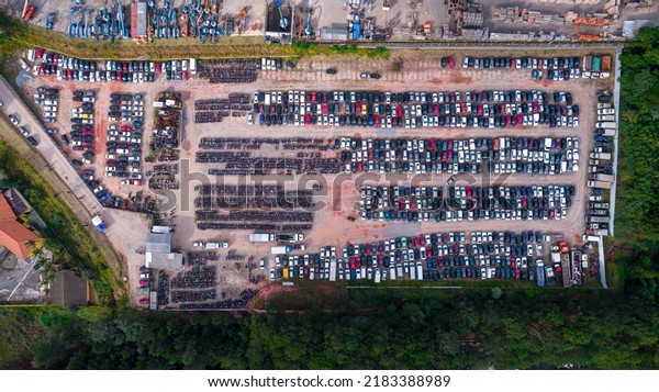 Yard\
of abandoned cars and seized for irregularity by the police. With\
many cars and many motorcycles parked. Aerial\
view