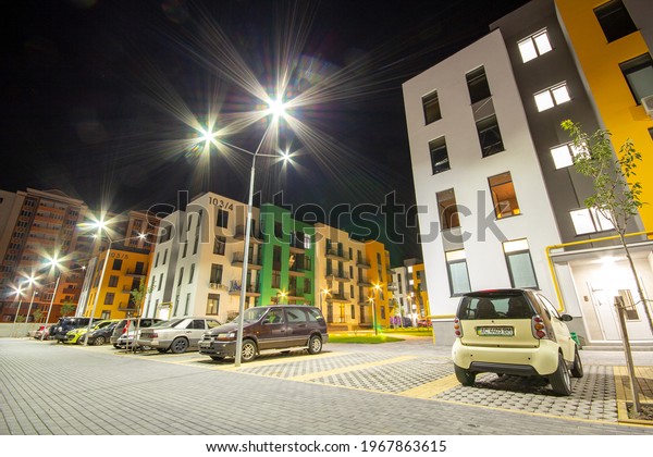 Yard between\
residential apartment buildings with parked cars and modern flat\
housing. Real estate\
development.