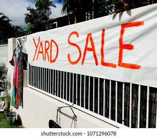 Yard sale painted sign attached to a fence 