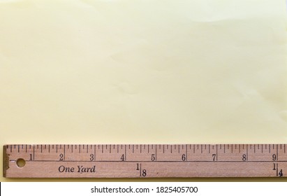 Yardstick placed on the bottom of the image with light yellow space on top for something to be measured in inches or yard fractions. Inches scale from 0 to 9 and yard scale from 0 to 1/4.