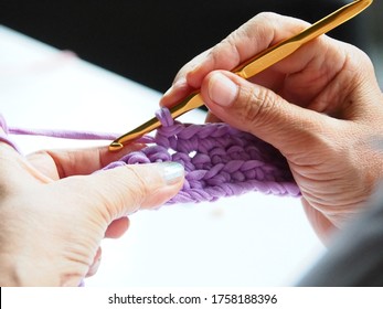 Yarn And Crochet Hook In Woman's Hand  Knitting Crochet Slipper. Elderly Leisure Activities For Good Mental Health Concept. Hand Craft, Hand Exercises, Hobby , Elderly Activity ,Art And Craft Concept.