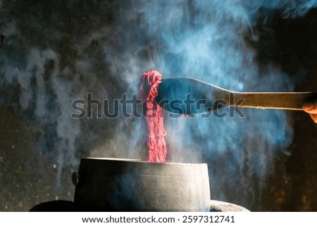 Yarn dyeing process by boiling method. The yarn is dyed with natural dye sources. The red dyed yarn is boiled in a hot kettle.