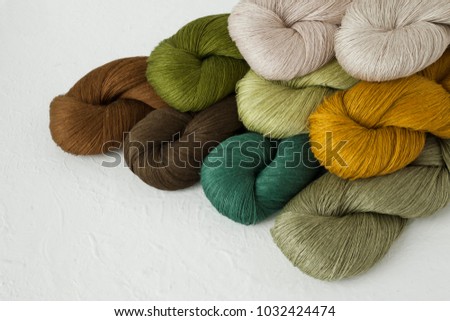 yarn skeins set in green and brown colors on white background, linen, cotton, craft, wool, yarn collection.