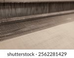 Yarn thread lines on the weaving loom machine. A loom machine for clothing or woven label. Weaving machine for garment industry. Weaving loom in textile factory.