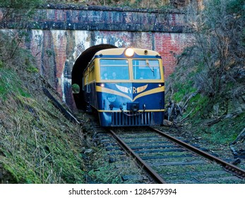 Yarra Valley,  Melbourne,  Victoria,  Australia. 
 July 2018, Blue And Yellow Tourist Train Coming Through A Tunnel.  Yarra Valley Rail. 

