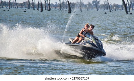 Yarrawonga, Victoria Australia - 17 April 2022: Young Couple Speeding Across Lake Mulwala On A Jetski Near Yarrawonga