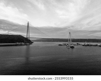 YAVUZ SULTAN SELIM BRIDGE Stunning Black and White View of a Modern Suspension Bridge over a Calm Body of Water. A tranquil black and white vista showcases a majestic suspension bridge spanning a calm - Powered by Shutterstock