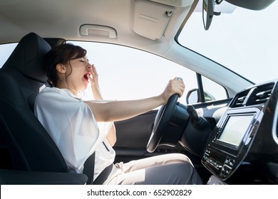 yawning female driver. falling asleep at the wheel concept.