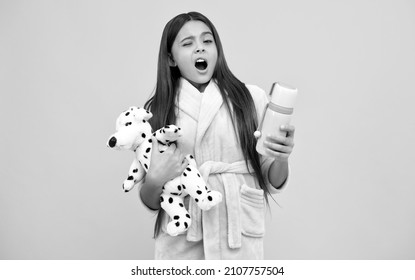 Yawning Teen Girl In Home Terry Bathrobe With Toy And Thermos Bottle, Yawn