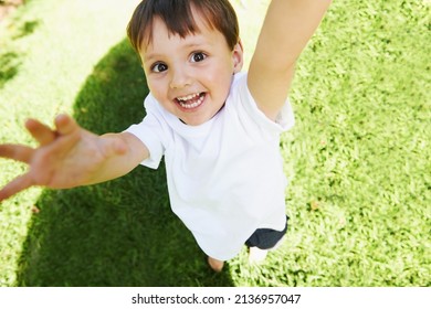 Yay Its Time To Play. High Angle View Of A Little Boy Reaching Up Into The Air.