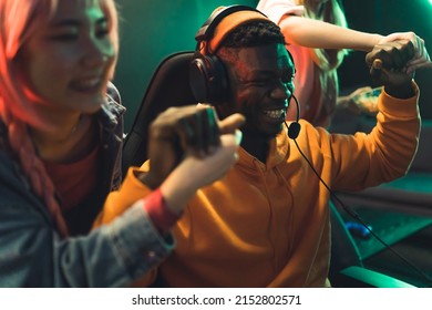 Yay, Victory. African-American Young Gamer Guy Holds Hands Of His Teammates Friends. Gaming Cafe Interior. High Quality Photo