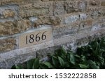 The year 1866 stamped into the side of a stone building to signify when it was built