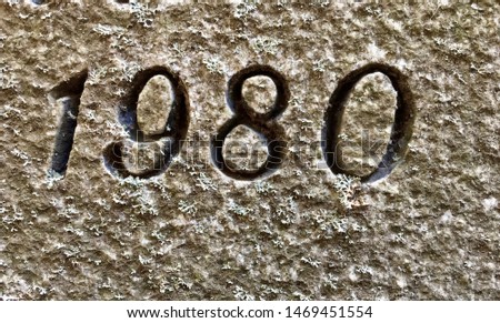 The year 1980 carved in stone and painted in black – a detail of an inscription produced that year. Covered with lichen