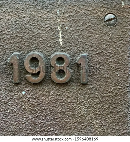 The year 1981 cast in metal – a detail of an inscription produced that year