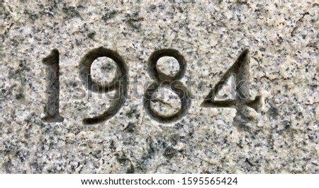 The year 1984 carved into granite – a detail of an inscription produced that year