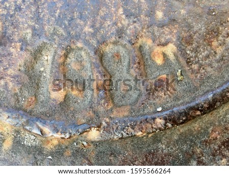 The year 1984 on a manhole cover made of iron and produced that year