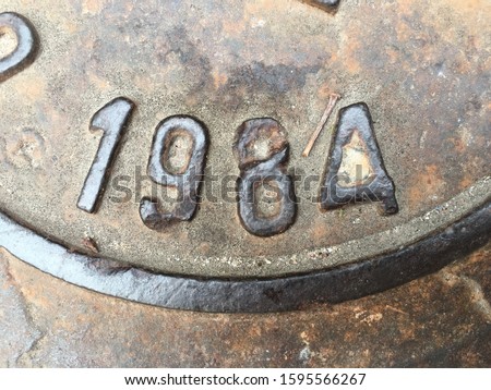 The year 1984 on a manhole cover made of iron and produced that year