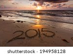 Year 2015 written on sand at sunset