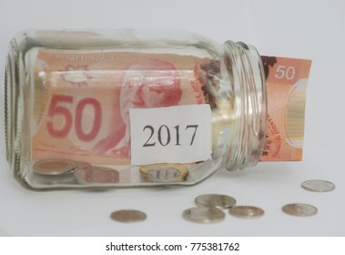 The Year 2017 Is Shown In A Mason Jar With Canadian Coins And A Fifty Dollar Bill