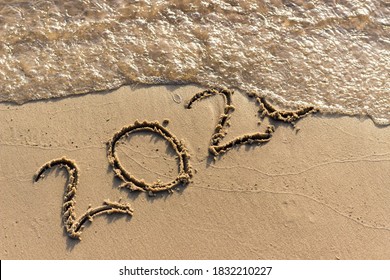 The Year 2020 Is Written On The Sandy Shore. 2020 Comes To An End And Is Washed Away By The Wave. Summer Background.