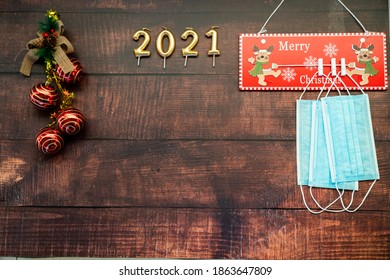 Year 2021 On Horizontal Dark Wood Background With Christmas Decoration And Masks Against Covid