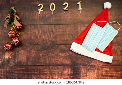 Year 2021 On Horizontal Dark Wood Background With Christmas Decoration And Masks Against Covid