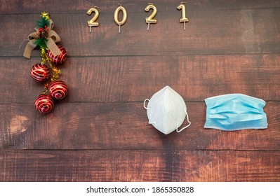 Year 2021 On Horizontal Dark Wood Background With Christmas Decoration And Masks Against Covid