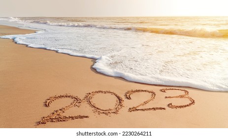 The year 2023- handwriting on sand beach, Happy New Year coming concept. White waves are lapping toward the shore. - Shutterstock ID 2230264211