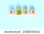 Year 2025 cryptocurrency bull run and recovery concept. Wooden blocks with bitcoin coin.