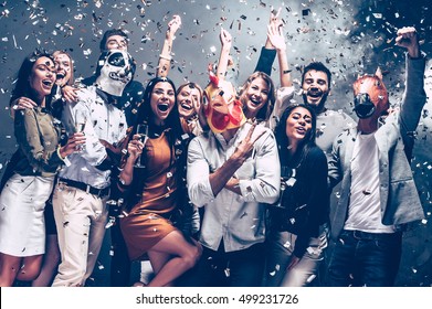 Year Of Rooster. Group Of Young People In Animal Masks Throwing Confetti And Looking Happy 